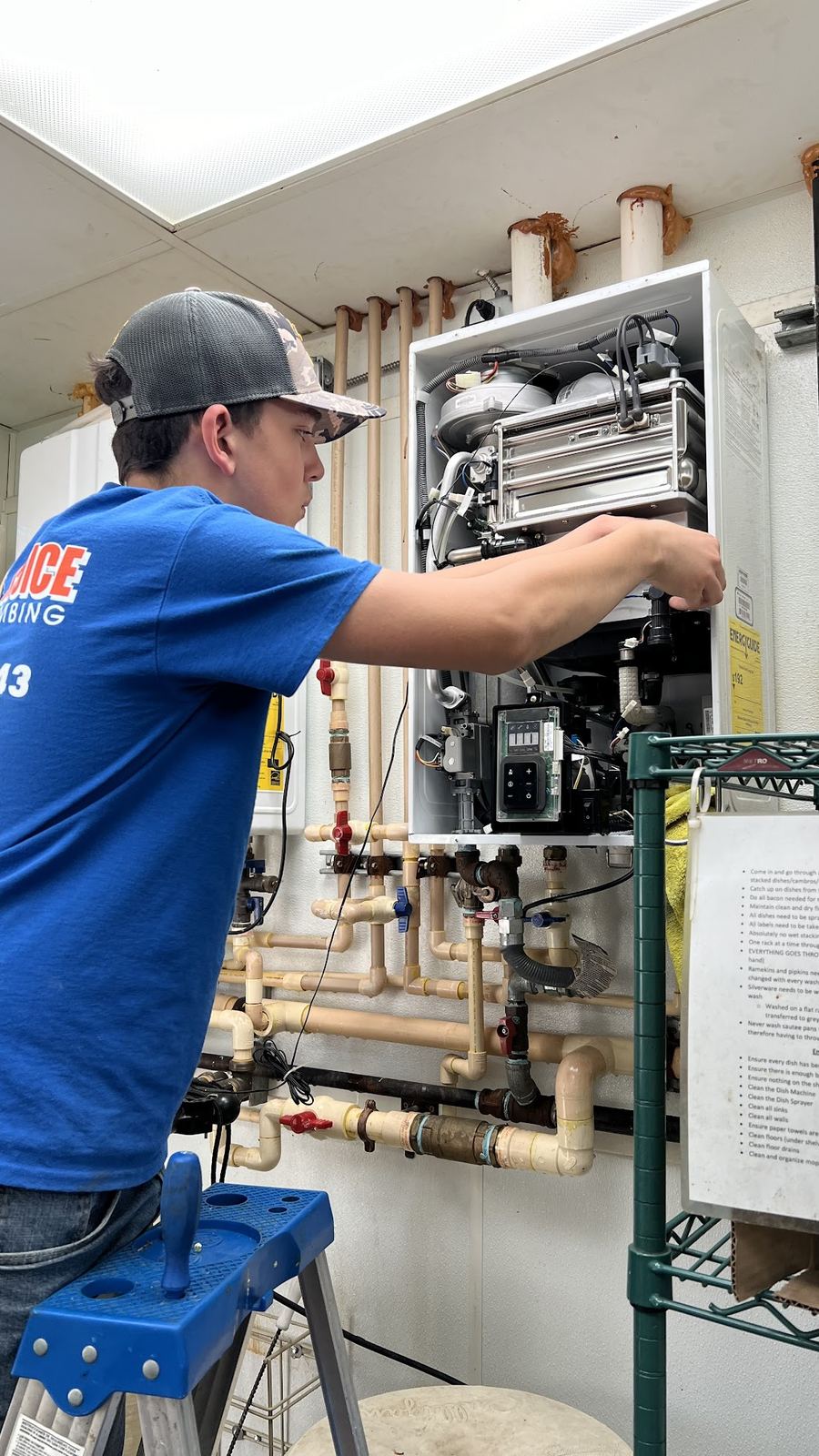 Choice Plumbing Orlando technician servicing an indoor tankless water heater with copper manifold