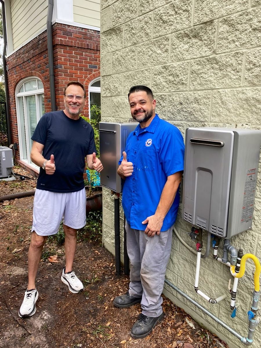 Happy Orlando homeowner with Choice Plumbing technician beside newly installed Rinnai outdoor tankless water heater