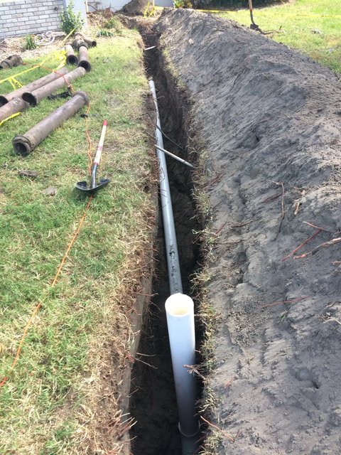 New PVC going in, with the old clay line pulled out beside it
