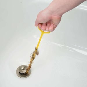 man removing hair from drain using a drain snake