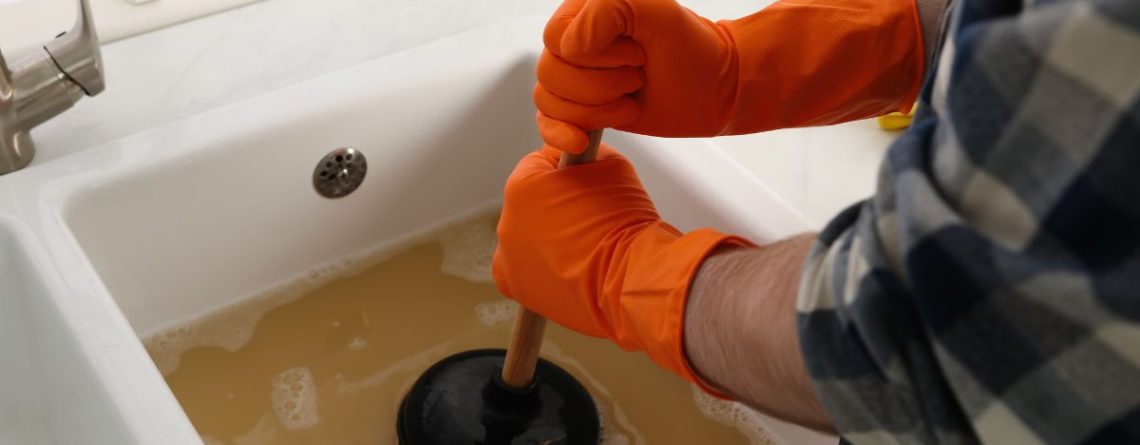 Homeowner using a drain plunger