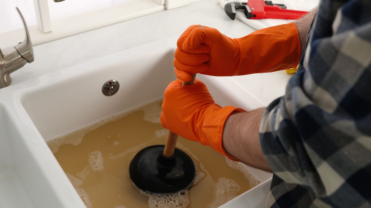 Homeowner using a drain plunger