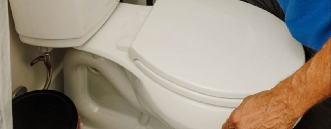 Plumber replacing an old toilet