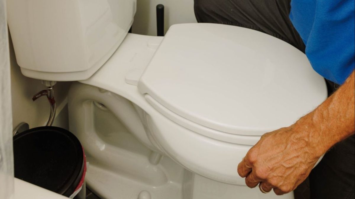 Plumber replacing an old toilet