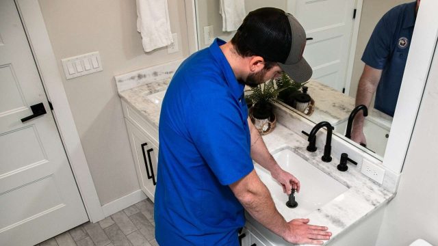 Plumber cleaning a sink drain