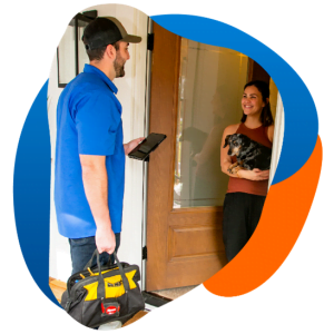 Technician arriving at a customer's home, greeted by a smiling woman holding a dog.