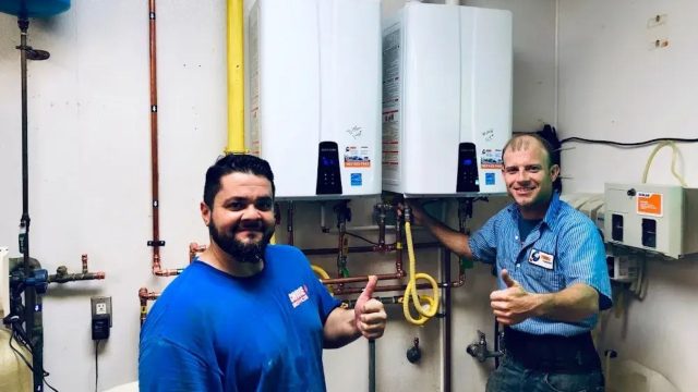 Plumbers installing water heater