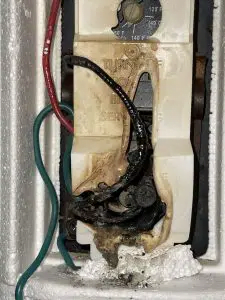 Burnt electrical component with damaged and exposed wiring.